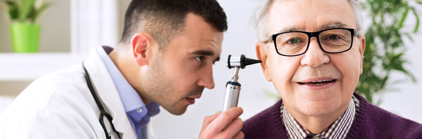 Doctor holding otoscope and examining patient ear
